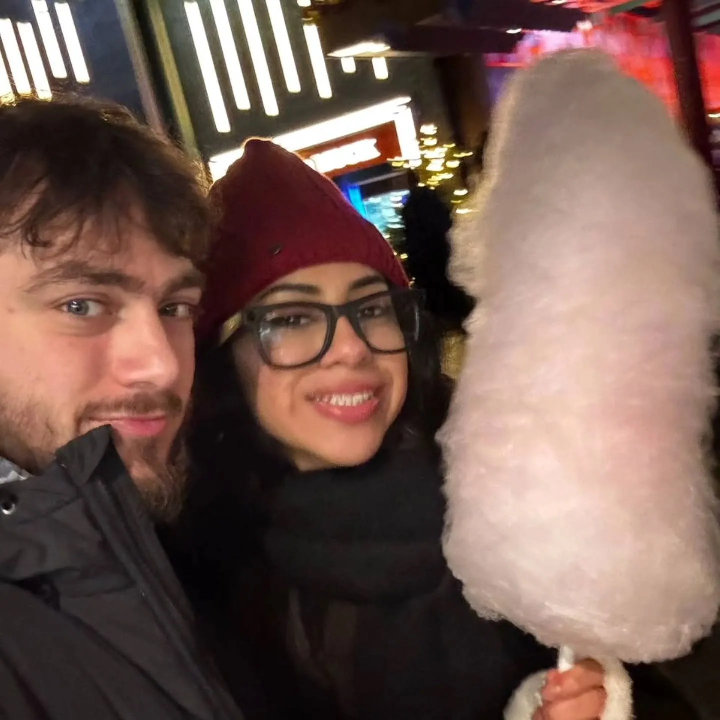 Michalis and Cristal sharing cotton candy at a night market